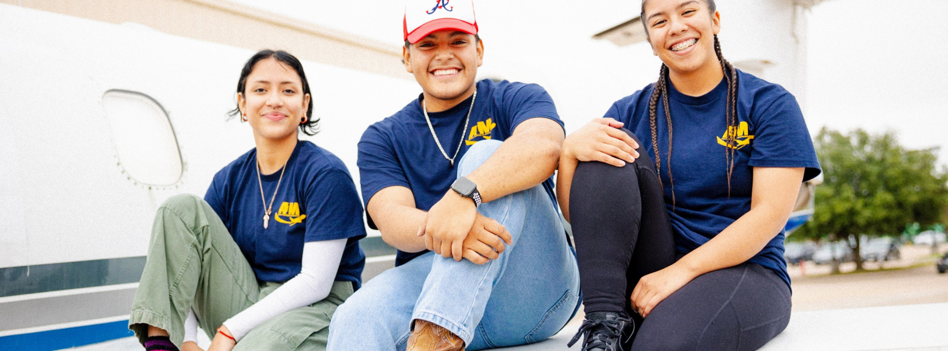 AIM students sitting together on plane wing