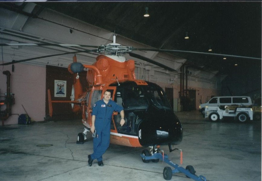 Chris Kraft in the Coast Guard standing in front of a helicopter