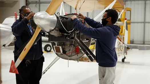 Two AIM A&P mechanics working on an airplane