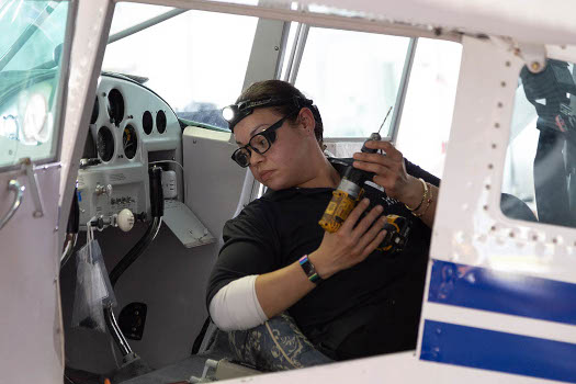 AIM alumni working on an airplane