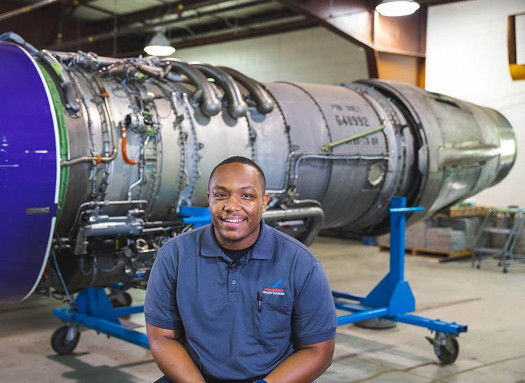 Man standing in front of airplane engine