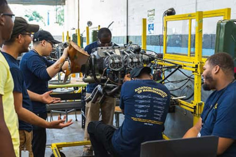 Aviation Maintenance Technical Engineer program students working on an engine