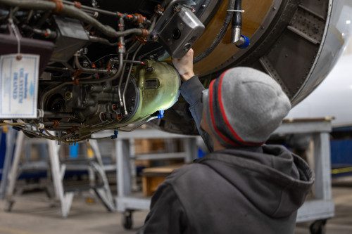 An AIM student doing maintenance on an airplane engine