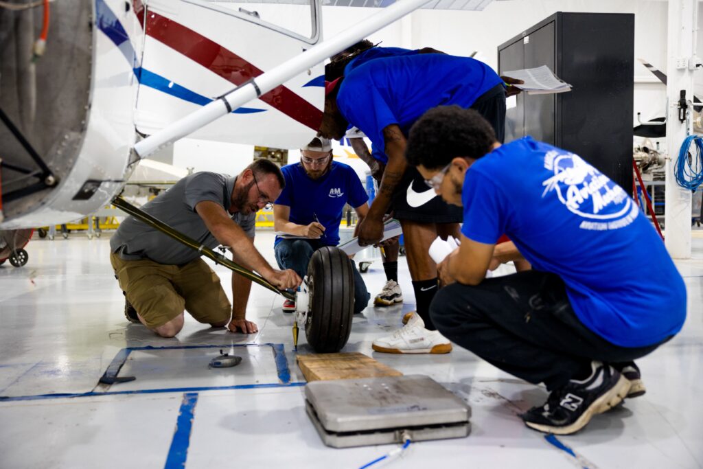 Aviation maintenance students at AIM performing hands-on aircraft inspection as part of their FAA certification training